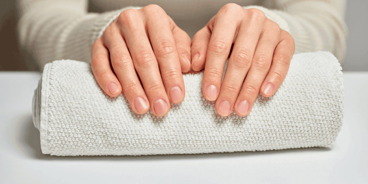 Mani femminili curate con unghie sane e forti al naturale, simbolo di benessere e bellezza.
